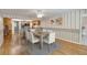 Dining area featuring hardwood floors, white chairs, and an adjacent breakfast bar at 3600 Aster Dr, Sarasota, FL 34233