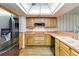 Updated kitchen with stainless steel refrigerator and wooden cabinets at 3600 Aster Dr, Sarasota, FL 34233