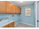 Functional laundry room boasts ample wooden cabinet storage and a utility sink at 3600 Aster Dr, Sarasota, FL 34233