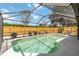 A screened-in pool is surrounded by a wooden fence and lush landscaping at 3600 Aster Dr, Sarasota, FL 34233