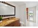 Bathroom with granite countertop, dark wood vanity, shower, and access to a patio with seating at 3941 Spyglass Hill Rd, Sarasota, FL 34238