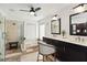 Bathroom featuring double sinks, dark cabinets, walk-in shower, soaking tub and modern fixtures at 3941 Spyglass Hill Rd, Sarasota, FL 34238