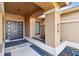 Inviting entryway with modern double doors, neutral stucco columns, and decorative rock garden accents creating a stylish entrance at 3941 Spyglass Hill Rd, Sarasota, FL 34238