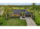 Beautiful single-story home featuring lush landscaping, a well-manicured lawn, and a dark roof, complemented by swaying palm trees at 3941 Spyglass Hill Rd, Sarasota, FL 34238