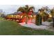 Back exterior view of home highlighting a screened in lanai and colorful landscaped yard at 3941 Spyglass Hill Rd, Sarasota, FL 34238