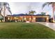 Beautiful single-story home featuring mature palms, manicured lawn, neutral tones, and a two-car garage at 3941 Spyglass Hill Rd, Sarasota, FL 34238