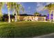 Charming single-story home with a manicured lawn, mature palms, and neutral tones at 3941 Spyglass Hill Rd, Sarasota, FL 34238