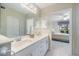 Bathroom with double sinks and a view into the bedroom through the open doorway at 400 Laurel Lake Dr # 104, Venice, FL 34292