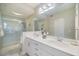 Bathroom featuring double sinks, white cabinetry, and a glass-enclosed shower at 400 Laurel Lake Dr # 104, Venice, FL 34292