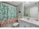 Well-maintained bathroom with tropical-themed shower curtain, white vanity, and neutral decor at 400 Laurel Lake Dr # 104, Venice, FL 34292