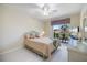 Cozy bedroom featuring wicker furniture and a sliding glass door to a private patio with lake view at 400 Laurel Lake Dr # 104, Venice, FL 34292