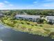 Exterior view of waterfront condos with palm trees and well-maintained landscaping near a tranquil lake at 400 Laurel Lake Dr # 104, Venice, FL 34292