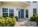 Inviting front entrance with a bright teal door, lovely plants, and decorative touches at 400 Laurel Lake Dr # 104, Venice, FL 34292