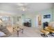 Open-concept living room featuring a ceiling fan, light walls, and seamless flow at 400 Laurel Lake Dr # 104, Venice, FL 34292