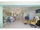Open-concept living space with light wood floors, comfortable seating, and a view of the dining area at 400 Laurel Lake Dr # 104, Venice, FL 34292