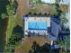 Aerial view of a refreshing community pool surrounded by lush landscaping and a serene lake at 400 Laurel Lake Dr # 104, Venice, FL 34292