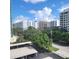 Cityscape view of neighborhood from a high-rise building showing lush greenery and other buildings on a partly cloudy day at 435 S Gulfstream Ave # 605, Sarasota, FL 34236
