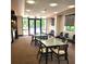 Community room with tables, chairs, neutral carpet, and large windows overlooking the outdoor area and pool at 435 S Gulfstream Ave # 605, Sarasota, FL 34236