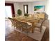 Staged dining room with a wooden table, wicker chairs, and a beach-themed painting on the wall at 435 S Gulfstream Ave # 605, Sarasota, FL 34236