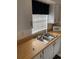Functional kitchen with wooden countertops, white cabinets, stainless steel sink and modern appliances at 4502 3Rd Street W Cir # 242, Bradenton, FL 34207
