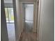 Hallway with wood-look tile leading to bright rooms and enclosed porch at 4505 3Rd Street W Cir # 269, Bradenton, FL 34207