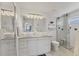 Bright bathroom features double sinks, granite countertop, walk-in shower, and white tile at 4911 Commonwealth Rd, Palmetto, FL 34221