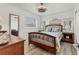Bright bedroom with a wooden bed frame, two windows, a ceiling fan, and wood-look flooring at 4911 Commonwealth Rd, Palmetto, FL 34221