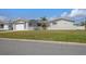 Inviting single-story home with a well-maintained lawn, white picket fence, and convenient attached garage at 4911 Commonwealth Rd, Palmetto, FL 34221