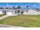 Charming single-story home featuring a manicured lawn, white picket fence, and an attached garage at 4911 Commonwealth Rd, Palmetto, FL 34221