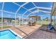 Stunning pool area featuring a screened enclosure, an outdoor table, and comfortable lounge chairs at 4911 Commonwealth Rd, Palmetto, FL 34221