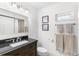 Bathroom featuring a dark vanity with granite countertop and framed artwork at 5055 Gulf Of Mexico Dr # 435, Longboat Key, FL 34228