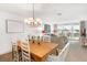 Bright dining room with a wooden table, white chairs, and a charming chandelier above at 5055 Gulf Of Mexico Dr # 435, Longboat Key, FL 34228