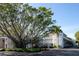 Exterior shot of multi-story building and parking area shaded by large banyan tree at 5055 Gulf Of Mexico Dr # 435, Longboat Key, FL 34228