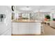 Bright kitchen featuring white cabinets, a center island, and an open view to the dining and living area at 5055 Gulf Of Mexico Dr # 435, Longboat Key, FL 34228