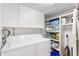 Bright laundry room with washer, dryer, storage cabinets, and shelving at 5055 Gulf Of Mexico Dr # 435, Longboat Key, FL 34228