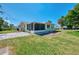 A backyard with a large green lawn features a screened patio and mature trees at 510 S Venice Blvd, Venice, FL 34293