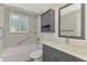 A full bathroom with gray vanity, a medicine cabinet, a shower/tub combo and grab bars at 510 S Venice Blvd, Venice, FL 34293