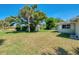 A huge backyard and green grass surround this home with lush, tropical landscaping at 510 S Venice Blvd, Venice, FL 34293