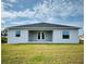 Rear exterior view of the home with a patio, large yard, and well-maintained lawn at 5113 Rilke Ln, Port Charlotte, FL 33981