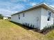 Side view of the home, highlighting the landscaping, windows, and exterior paint at 5113 Rilke Ln, Port Charlotte, FL 33981