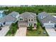 Aerial view of a two-story home with a brick driveway, surrounded by mature trees and landscaping at 5252 Bentgrass Way, Bradenton, FL 34211