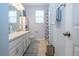 Bathroom featuring double vanity, white cabinets, and shower with blue-patterned shower curtain at 5252 Bentgrass Way, Bradenton, FL 34211