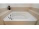 Bright bathroom featuring a soaking tub with tiled surround and a decorative vase at 5252 Bentgrass Way, Bradenton, FL 34211
