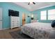 Bedroom with blue walls, ceiling fan, wood floors and a large window at 5252 Bentgrass Way, Bradenton, FL 34211