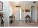 Bright foyer featuring wood-look tile flooring, a white front door with sidelight, and elegant console tables at 5252 Bentgrass Way, Bradenton, FL 34211