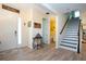 Open foyer with wood-look floors, a white door, staircase, and decorative accents, creating a welcoming entrance at 5252 Bentgrass Way, Bradenton, FL 34211