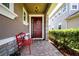 Inviting front entry with a red door and a decorative wreath, bench seating and brick pathway at 5252 Bentgrass Way, Bradenton, FL 34211