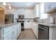 Kitchen with white cabinets, stainless steel appliances, granite countertops, and modern fixtures at 5252 Bentgrass Way, Bradenton, FL 34211