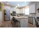 Modern kitchen with stainless steel appliances, granite countertops, and a breakfast bar with stool seating at 5252 Bentgrass Way, Bradenton, FL 34211