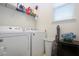 Functional laundry area with white appliances, storage shelf and natural light from the window at 5252 Bentgrass Way, Bradenton, FL 34211